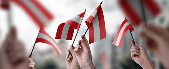 A group of people holding small flags of the Austria in their hands