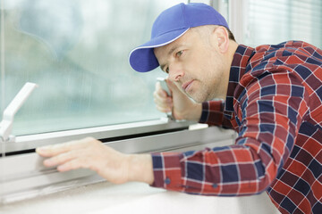 Naklejka na ściany i meble workman checking aluminium window frame