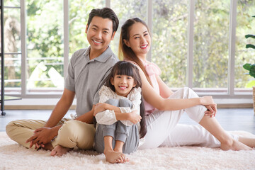 Real estate and mortgage concept : Family with child having fun in new home. Joyful first-time buyers in living room. Real estate, residential mortgage, moving into dream house.
