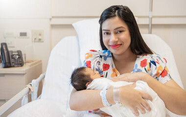 Closeup portrait of young asian Indian hispanic mother day holding newborn baby with copy space....