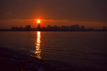 Naklejka premium Sunset over the city, Batumi , Adjara, Georgia. sunlight cityscape view of Batumi city at golden hour. Black Sea port of Batumi, capital of Adjara. Sun set. panorama of the city of batumi at sunset.