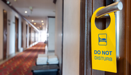 The sign Do Not Disturb hangs on the doorknob of the hotel room