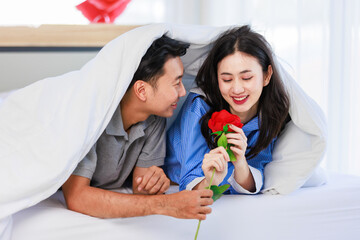 Asian young romantic lover couple male boyfriend giving red rose surprising female girlfriend...