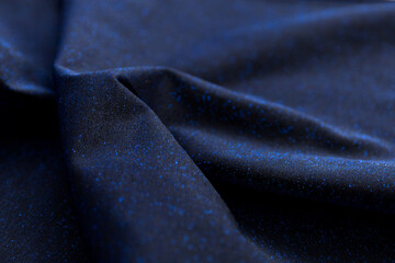 Defocused blurred blackfabric with sparkling blue lurex as background