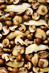 Different types of mushrooms prepared for grilling on a grill plate, top view. Mushroom background