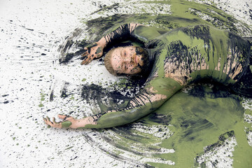 portrait and upper body of young sexy naked man in black green camouflage color painted, lies...