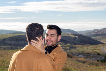 latino man in love touching his caucasian boyfriend's face. romantic gay couple
