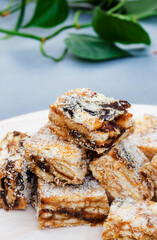 classic date squares sprinkled with coconut on light wooden surface