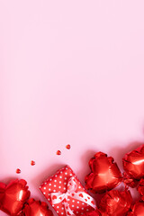 . Valentines Day background with Gift box, candels and red heart shape balloons on pink