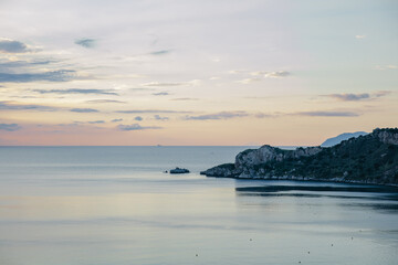 Fototapeta premium rocky seashore overlooking the evening sky in the clouds, the islands in the distance, Sicily, Italy