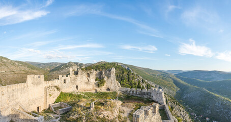 Fototapeta na wymiar Panorama of ruins of a medieval castle with vegetation coming back
