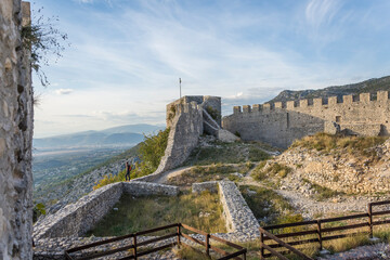 Ruins of a medieval castle with vegetation coming back and a panoramic view of the valley bellow