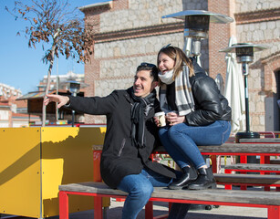 Fototapeta premium Couple dating in a coffeehouse bar - Tourists talking and having fun while sightseeing the city