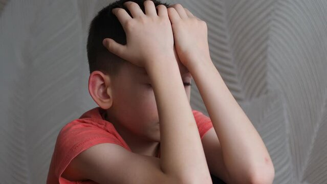 Portrait Sad Depressed Caucasian Boy 9 Years Old Covers His Face With His Hands Is Experiencing A Loss.the Child Is Sad Thinking. The Boy Worries About The Loss Being Inside