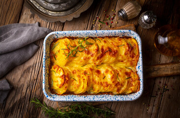 Potato gratin - graten (baked potatoes with cream and cheese) with rosemary and forks (Turkish...