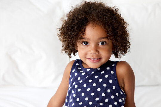 Portrait of smiling young girl with afro hair wearing polka dot tank top