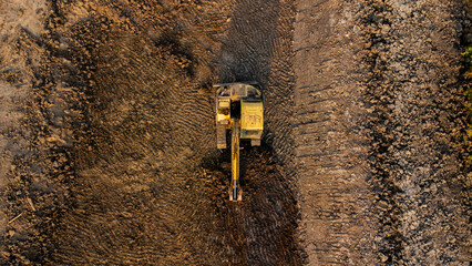 Excavator dig ground at construction site. Aerial view of a wheel loader excavator with a backhoe...