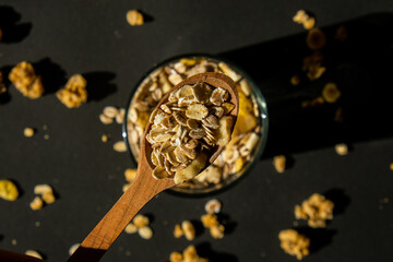 Homemade oatmeal granola with nuts and seeds in eco tableware jar. Healthy snack on breakfast. Muesli from oatmeal, raisins, honey, cranberry, flax, almond, cashew, freshly baked