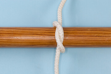 Rope simple overhand knot tied around a wooden pole