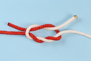 Not tightened rope Surgeon's knot on a blue background