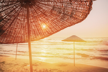 Wicker Beach Umbrella At Mediterranean Resort. Vacation Concept. Advertising Travel Company. Beach Umbrella On Idyllic Tropical Sand Beach. Concept For Rest, Relaxation, Holidays, Spa, Resort Design. © Great Brut Here