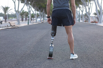 Crop runner with artificial blade leg standing on asphalt road