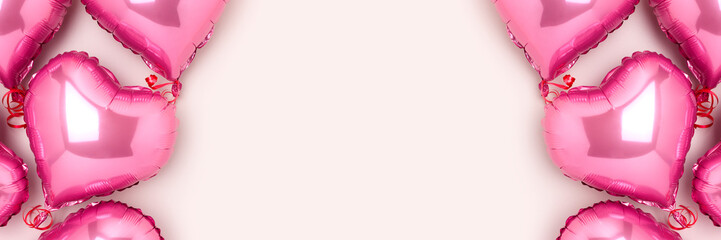 Banner with frame made of pink inflatable balloons in a heart shape. Composition on a gray background.