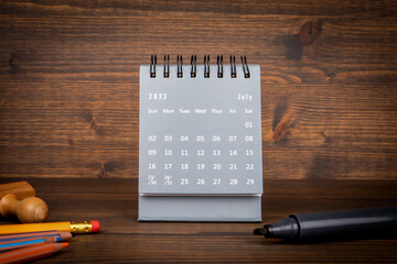2023 July. Black paper calendar on a wooden table. Time planning, day counting and holidays