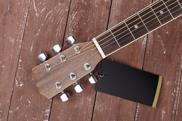 Musical instrument - Top view headstock left handed acoustic guitar tag on wooden background