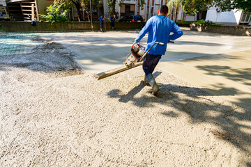 Worker is using power tool with engine, compactor, for level and compact fresh concrete
