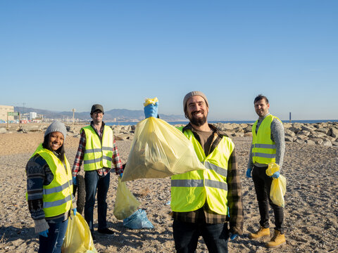 Group of young ecologist volunteers collecting garbage