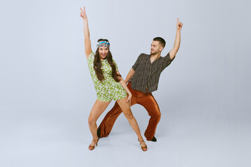 Stylish emotional young man and woman in fashionable retro outfits dancing disco dance isolated...