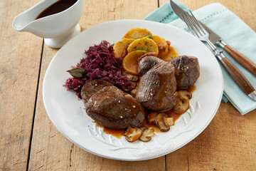 Meat dish near sauce and cutlery