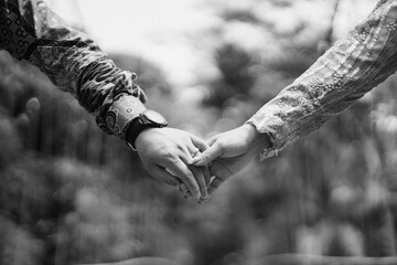 a couple of lovers holding hands close up. photographed in black and white