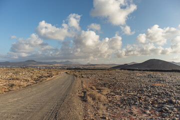 Beautiful sunset in a desert area with white clouds, mountains and town in the background, Fuerteventura Canary Islands.jpg