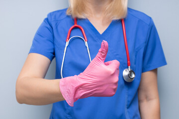 doctor in uniform in hospital holding thumb up.