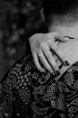 close up of the bride's hands embracing the groom, photographed in black and white