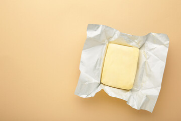 Stick of butter on beige background.