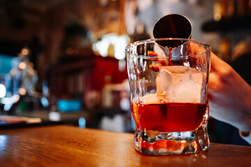 woman hand bartender making negroni cocktail