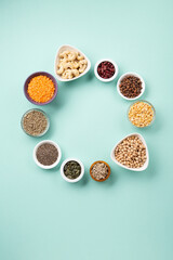 Healthy Dry Pea Protein Powder and Plant Based Protein Food (legumes, lentils, beans, seeds) on Blue Green Background.