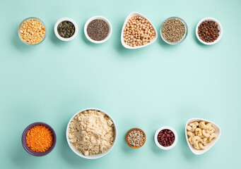 Healthy Dry Pea Protein Powder and Plant Based Protein Food (legumes, lentils, beans, seeds) on Blue Green Background.