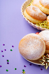 Mardi Gras King Cake Doughnuts or Donuts, Carnival Masks on Purple Background.