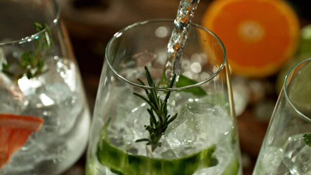 Super slow motion of preparing gin and tonic drinks with speed motion. Filmed on high speed cinema camera, 1000 fps, placed on high speed cine bot. Bar with bottles on background.