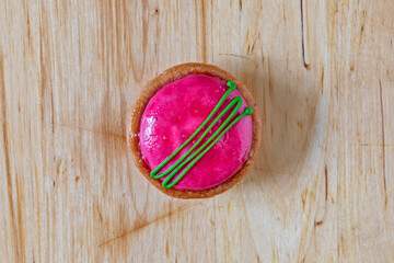 Small round tartlet with fuchsia-coloured icing.