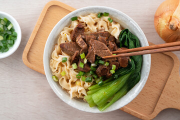 Beef noodle soup. Taiwanese famous food in a bowl on wooden table.