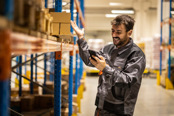 Portrait of a young happy warehouse worker , working and packaging boxes and prepairing it to deliver