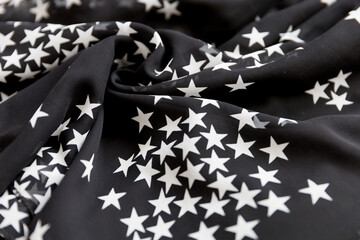 Black folded fabric with white stars pattern as texture background