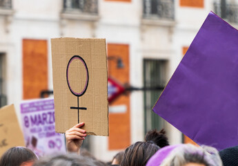 Women hands supporting feminist symbol placard on 8 M demonstration