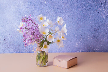 Lilac and anemones flower bouquet with gift box. Spring, Mother's Day or March 8 greeting concept