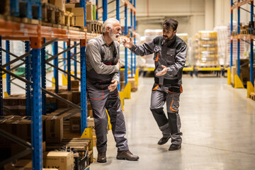 Warehouse situation, young worker comes to help senior worker, he got injured when carring heavy boxes